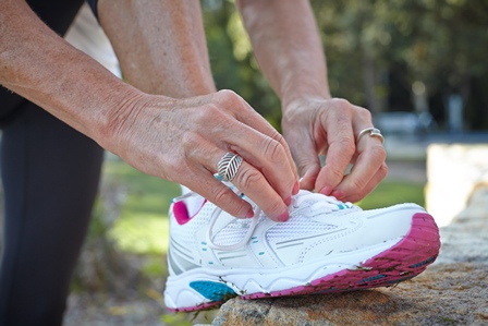 Close up of a woman tying up her left sneaker