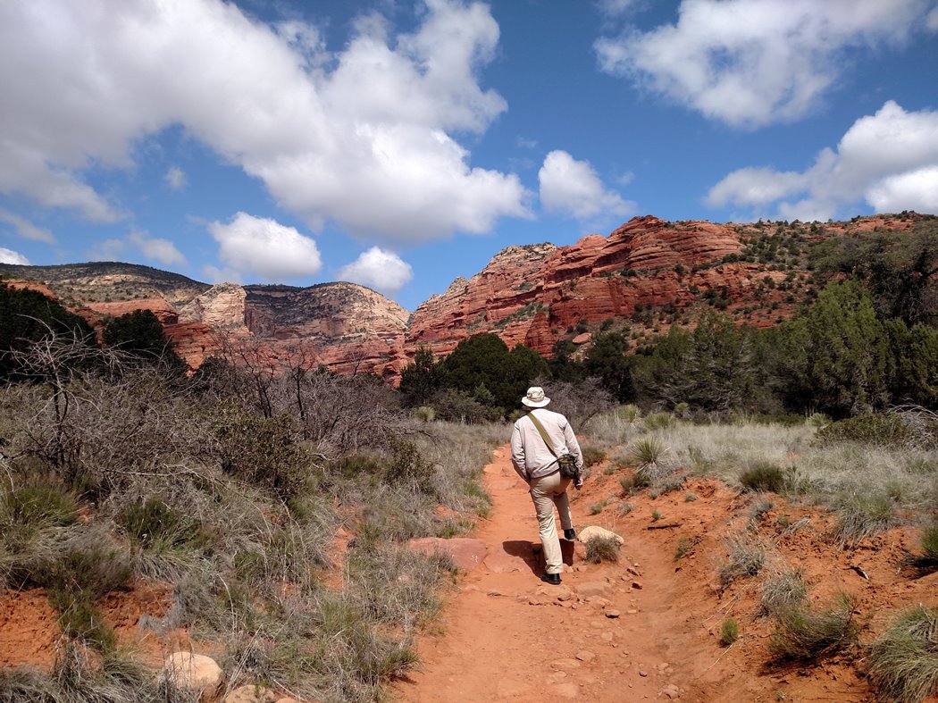 Man hikes over red dirt