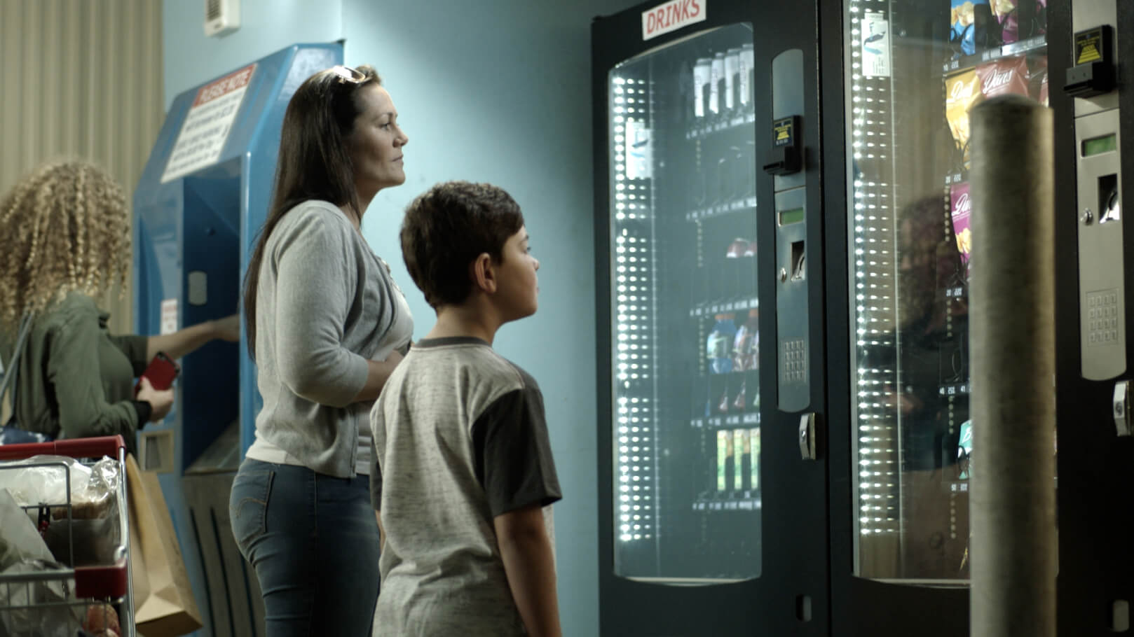 woman and her son looking at a vending machine